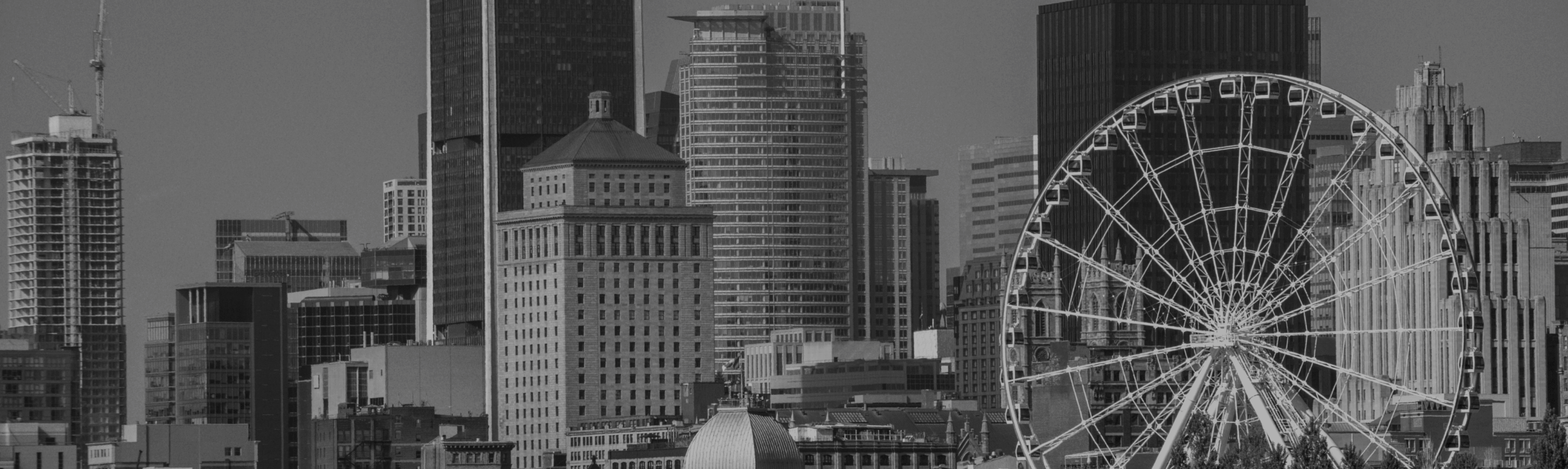 Black-and-white panoramic city skyline with a large Ferris wheel on the right side.