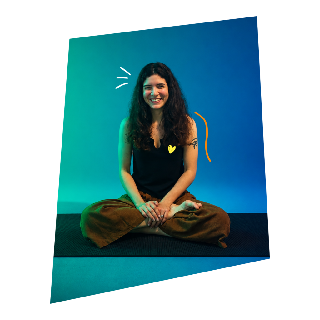Smiling woman with long dark hair sits cross‑legged on a yoga mat against a teal‑to‑blue gradient backdrop.